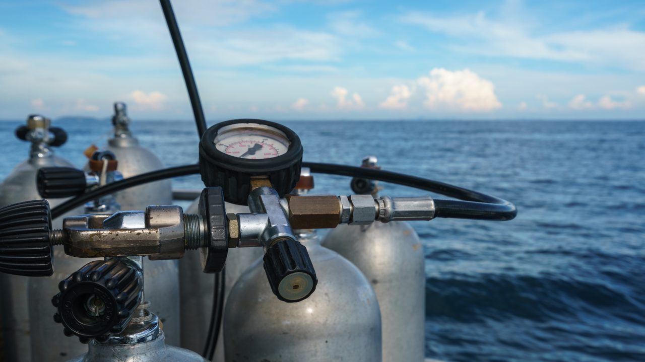 A submersible pressure gauge (SPG) in a diver's hand